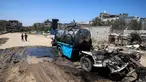 Seorang anak laki-laki mengambil air ke dalam jeriken dari kendaraan mobile tangki air yang hancur akibat pengeboman Israel di kamp Nuseirat untuk pengungsi Palestina di Jalur Gaza tengah pada 14 Juli 2025. (Eyad BABA/AFP)