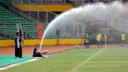 Petugas lapangan menyirami rumput jelang laga timnas Indonesia U-23 melawan Korea Selatan di kualifikasi grup H Piala Asia 2016 di Stadion GBK Jakarta, Selasa (31/3/2015). Indonesia U-23 kalah 0-4 dari Korea Selatan. (Liputan6.com/Helmi Fithriansyah)
