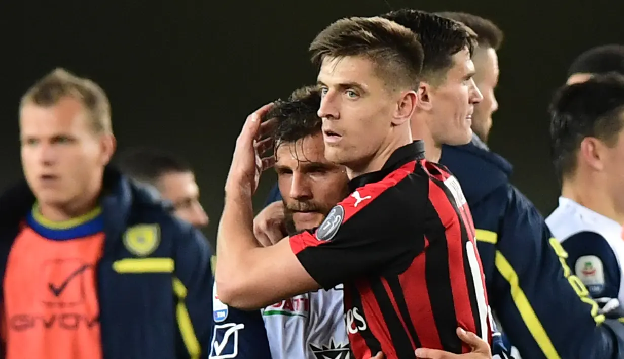 Striker AC Milan Krzysztof Piatek merangkul gelandang Chievo Perparim Hetemaj pada akhir laga pekan ke-27 Liga Italia di Stadion Marcantonio Bentegodi, Verona, Sabtu (9/3). Piatek mencetak gol penentu untuk kemenangan AC Milan. (Miguel MEDINA/AFP)
