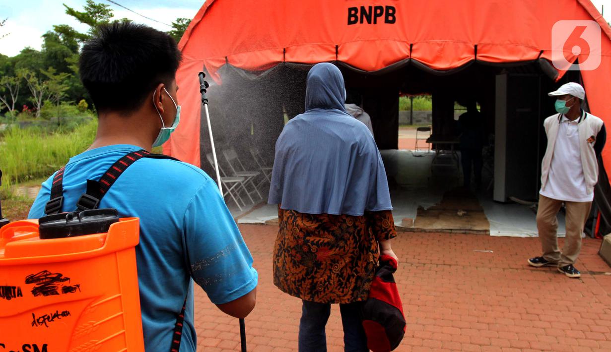 Warga disemprot disinfektan sebelum pulang  usai menjalani isolasi mandiri bagi pasien positif  OTG di Rumah Lawan Covid-19 Tangerang Selatan, Jumat (1/1/2021). Pasien Covid-19 baru yang hendak diisolasi di RLC harus menunggu peserta karantina RLC pulang terlebih dahulu secara berkala. (merdeka.com/