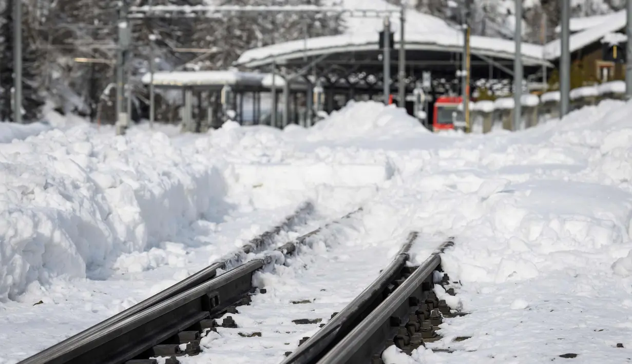 Kondisi rel kereta api yang tertutup salju tebal di desa Taesch, Pegunungan Alpen Swiss, (10/1). Pemadaman listrik di beberapa daerah lain, seperti di Kota Valais, juga terjadi akibat hujan salju lebat. (AFP Photo/Fabrice Coffrini)