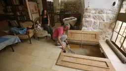 Tal bersama keluarga saat berada diruang tamu menuju pintu masuk kolam ritual Yahudi (Mikveh) di Ein Karem, Yerusalem (1/7/2015). Tal menemukan Mikveh yang diyakini berusia lebih dari 2.000 tahun saat sedang merenovasi rumah.  (AFP/GALI TIBBON)