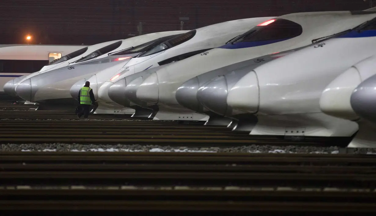 Petugas mengecek kereta berkecepatan tinggi di pusat perawatan di Wuhan, provinsi Hubei, China, (1/2). Jelang Imlek, pihak berwenang memperkirakan lebih 390 juta perjalanan kereta api berlangsung antara 1 Februari-12 Maret. (AFP Photo)