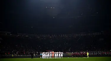 Pemain Tottenham (Kiri) dan pemain AC Milan (Kanan) bersatu untuk mengheningkan cipta untuk memperingati para korban gempa bumi yang melanda Turki dan Suriah, sebelum pertandingan babak 16 besar Liga Champions di stadion San Siro di Milan pada 15 Februari 2023. (AFP/Marco Bertorello)