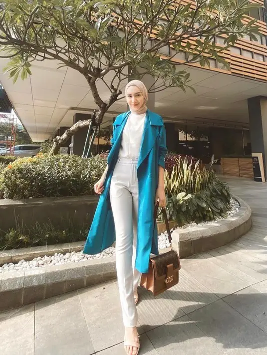 Tampil lebih elegan, dengan padu padan blouse, long coat, dan celana jeans putih ala artis Melody Prima satu ini. (Instagram/melodyprima).