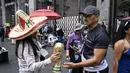 Seorang pedagang kaki lima menunjukkan suvenir berbentuk piala Piala Dunia kepada pejalan kaki di Mexico City pada Senin 8 Juni 2026. (Yuri CORTEZ/AFP)