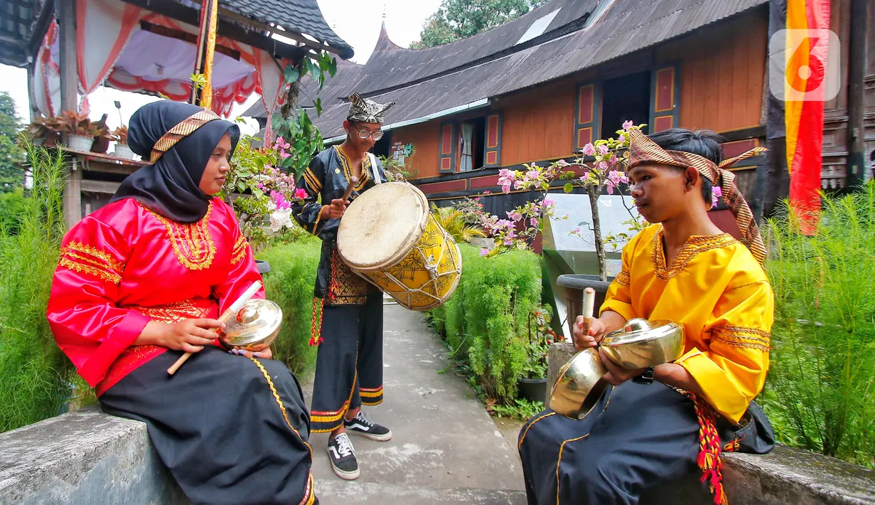 Para pemuda memainkan alat musik kesenian tradisional di Desa Wisata Kampuang Minang Nagari Sumpu, Kabupaten Tanah Datar, Provinsi Sumatera Barat, Kamis (22/6/2023). (Liputan6/Angga Yuniar)