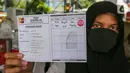 Warga menunjukkan kartu test Covid-19 usai rapid test massal di Kantor Kelurahan Pondok Betung, Tangerang Selatan, Kamis (14/5/2020). Rapid test yang digelar Badan Intelijen Negara (BIN) untuk memastikan positif atau tidaknya warga terjangkit Covid-19. (Liputan6.com/Fery Pradolo)