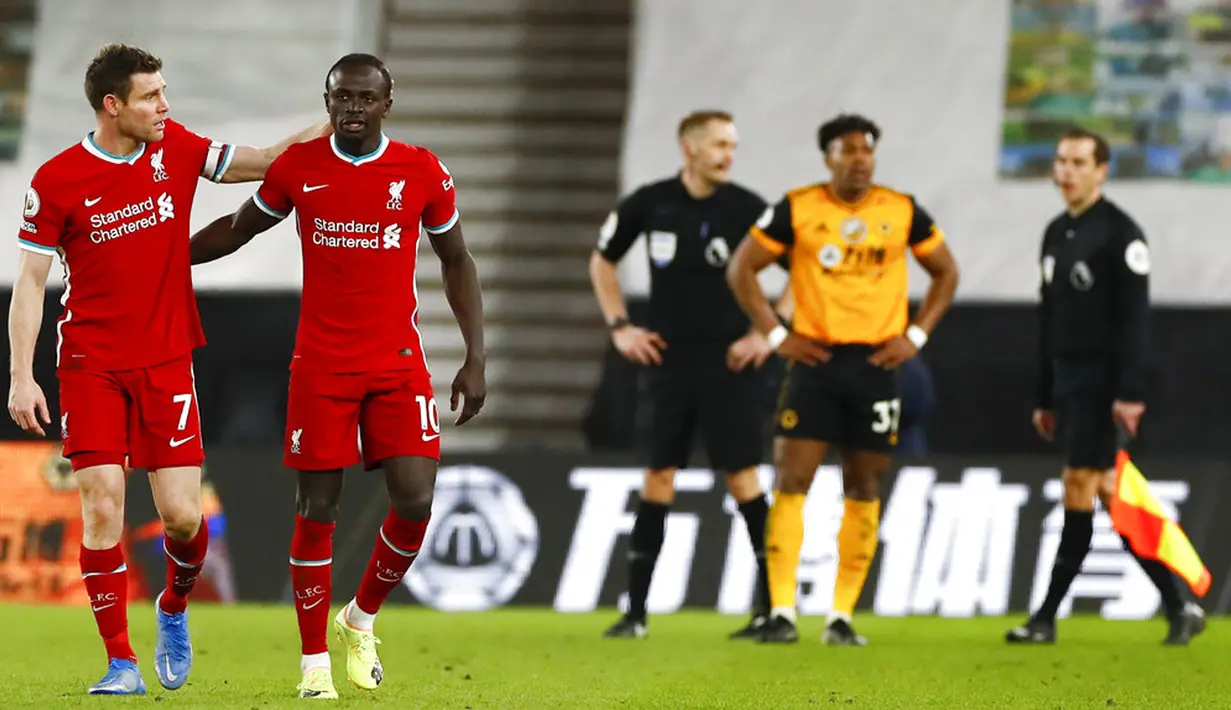 Pemain Liverpool James Milner (kiri) dan rekan setimnya Sadio Mane bereaksi usai melawan Wolverhampton Wanderers pada pertandingan Liga Inggris di Stadion Molineux, Wolverhampton, Inggris, Senin (15/3/2021). Liverpool menang 1-0. (AP Photo/Jason Cairnduff,Pool)
