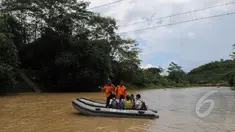 Sejumlah siswa menyeberangi sungai Ciberang mengunakan perahu karet milik BNPB di Lebak, Banten, Senin (16/3). Pasca robohnya jembatan gantung di atas Sungai Ciberang, warga terpaksa menyeberang mengunakan perahu karet. (Liputan6.com/Herman Zakharia)