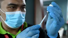 Seorang petugas kesehatan menyiapkan vaksin penguat virus corona Covid-19 Inavac di Bandara I Gusti Ngurah Rai, Bali, pada 29 Desember 2023. (SONNY TUMBELAKA/AFP)