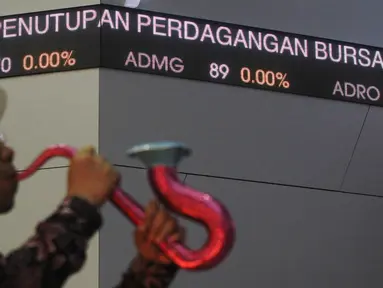 Pegawai meniupkan terompet usai penutupan perdagangan saham tahun 2015 di Bursa Efek Indonesia, Jakarta, (30/12). Indeks Harga Saham Gabungan (IHSG) pada akhir 2015 ditutup‎ menguat 23,65 poin atau 0,52 persen. (Liputan6.com/Angga Yuniar)
