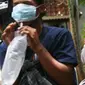 Warga meniupkan kantong saat menjalani tes deteksi COVID-19 dengan metode GeNose C19 usai terjaring razia penggunaan masker di Kelurahan Sudimara Barat, Kota Tangerang, Kamis (27/5/2021). Tes tersebut untuk menekan penyebaran corona di wilayah tersebut. (Liputan6.com/Angga Yuniar)