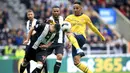 Striker Arsenal, Pierre-Emerick Aubameyang, berebut bola dengan pemain Newcastle United, Javier Manquillo, pada laga Premier League 2019 di Stadion St James' Park, Minggu (11/8). Arsenal menang 1-0 atas Newcastle United. (AP/Owen Humphreys)