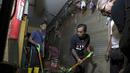 Para pria membersihkan sisa-sisa banjir di Badung, Bali, pada Jumat 12 September 2025. (AP Photo/Firdia Lisnawati)