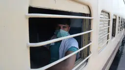 Seorang buruh migran memandang dari balik jendela ketika menaiki kereta khusus menuju rumahnya saat masa karantina wilayah (lockdown) nasional diterapkan demi mencegah penyebaran COVID-19 di Jalandhar, Negara Bagian Punjab, India utara, (5//5/2020). (Xinhua/Stringer)