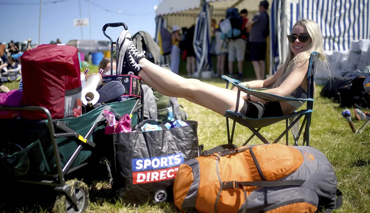 Seorang wanita beristirahat di hari pertama Festival Glastonbury di Worthy Farm di Somerset, Inggris, Rabu (22/6/2022). Pandemi virus corona memaksa penyelenggara membatalkan acara, dan mereka yang pergi tahun ini menghadapi perjalanan yang sulit melawan tiga hari pemogokan kereta api besar di seluruh negeri. (Yui Mok/PA via AP)