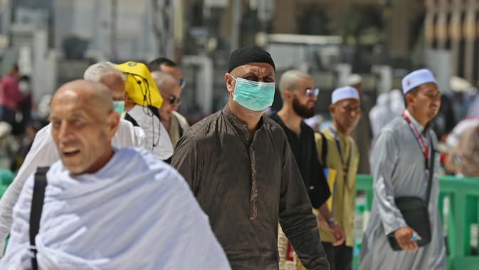 Umat Muslim mengenakan masker di Masjidil Haram, kota suci Makkah, Kamis (27/2/2020). Suasana Masjidil Haram berjalan sebagaimana biasanya pascapengumuman Pemerintah Arab Saudi yang melarang sementara jemaah umrah ke Tanah Suci terkait pencegahan penyebaran virus korona. (Abdulghani BASHEER/AFP)