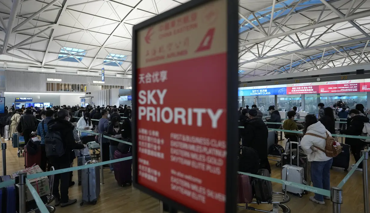 Penumpang antre menaiki pesawat menuju China di Bandara Internasional Incheon di Incheon, Selasa (10/1/2023). China menangguhkan visa pada Selasa bagi warga Korea Selatan yang datang ke negara itu untuk pariwisata atau bisnis sebagai pembalasan yang nyata untuk persyaratan pengujian COVID-19 pada pelancong China. (AP Photo/Ahn Young-joon)