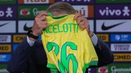 Pelatih kepala tim nasional sepak bola Brasil yang baru, Carlo Ancelotti memegang jersey tim nasional yang diterimanya saat memberi keterangan terkait nama-nama pemain yang akan bertanding di kualifikasi Piala Dunia melawan Ekuador dan Paraguay, di Rio de Janeiro, Senin 26 Mei 2025. (AP Photo/Silvia Izquierdo)