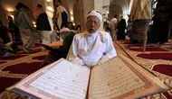 Seorang pria membaca Al-Quran selama bulan Ramadan di Masjid Agung Sanaa, Yaman, Minggu (26/4/2020). Kaligrafi dan dekorasi merupakan kekhasan Masjid Agung Sanaa. (Mohammed HUWAIS/AFP)