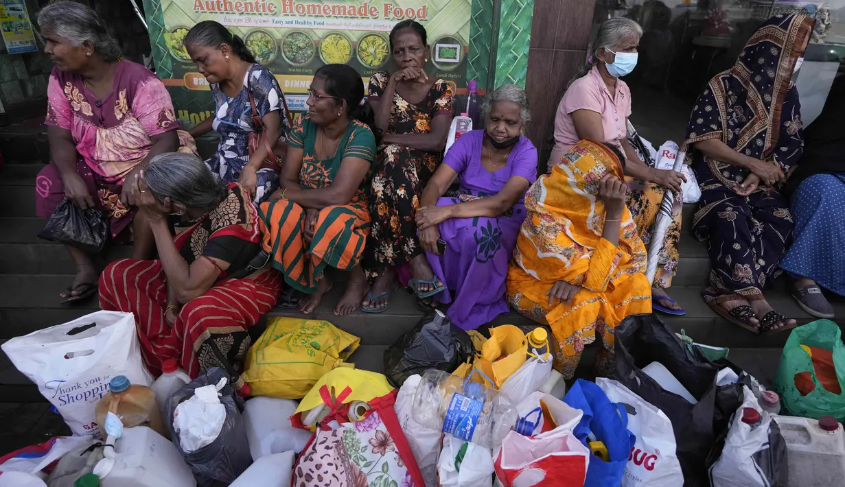 Sejumlah perempuan menunggu di dekat pompa bensin kosong berharap untuk membeli minyak tanah untuk memasak di Kolombo, Sri Lanka, Kamis (26/5/2022). Warga Sri Lanka selama berbulan-bulan terpaksa antre panjang untuk membeli kebutuhan pokok yang langka, dengan banyak yang pulang dengan tangan hampa. (AP Photo/Eranga Jayawardena)