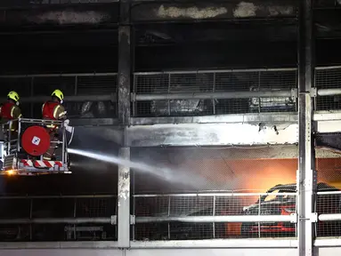 Petugas pemadam kebakaran memadamkan api di Bandara Luton London yang menyebabkan runtuhnya sebagian bangunan parkir di Luton, Rabu (11/10/2023). (HENRY NICHOLLS / AFP)