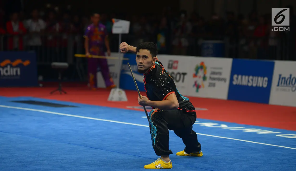 Atlet Wushu Indonesia Hulaefi Achmad beraksi pada laga final Men's Daoshu dan Gunshu Asian Games 2018 di JIexpo,Hall B, Kemayoran, Jakarta, Selasa (21/8). Achmad berhasil meraih perunggu dan sukses merebut total 19,41 poin. (Merdeka.com/Imam Buhori)