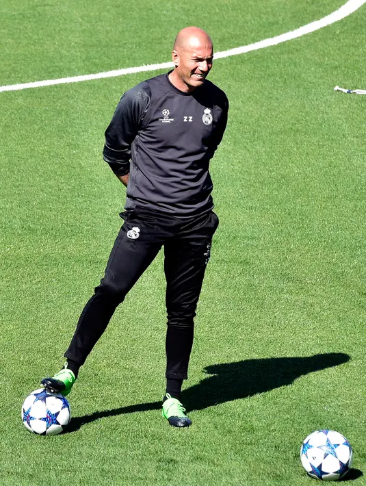 Pelatih Real Madrid, Zinedine Zidane melihat para pemain mengikuti sesi latihan di Valdebebas, Madrid, Spanyol (17/4). Real Madrid akan menantang Bayern Muenchen di leg kedua perempat final Liga Champions. (AFP Photo / Gerard Julien)