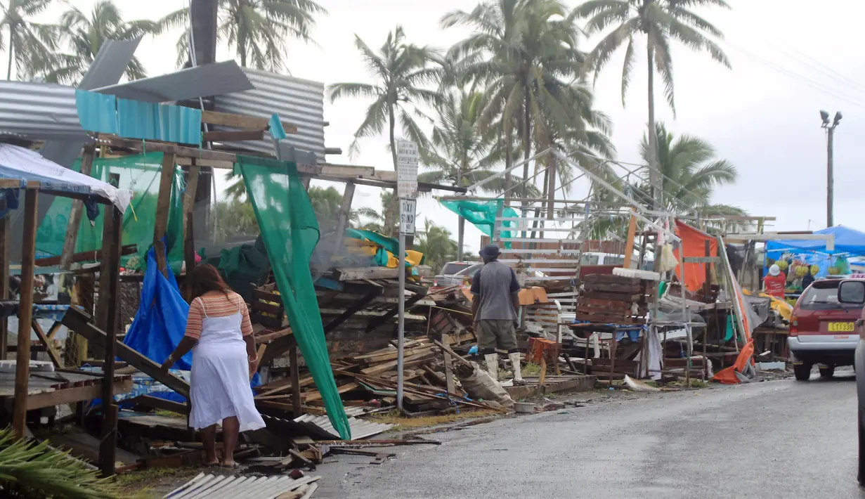 Pedagang membereskan lapak di sebuah pasar buah dan sayur yang hancur akibat diterjang badai dahsyat di Ibu kota Fiji, Suva, Senin (22/2). Badai Winston memporak-prandakan negara kepulauan Fiji hingga menewaskan sedikinya 10 orang. (REUTERS/Sarah Boxall)