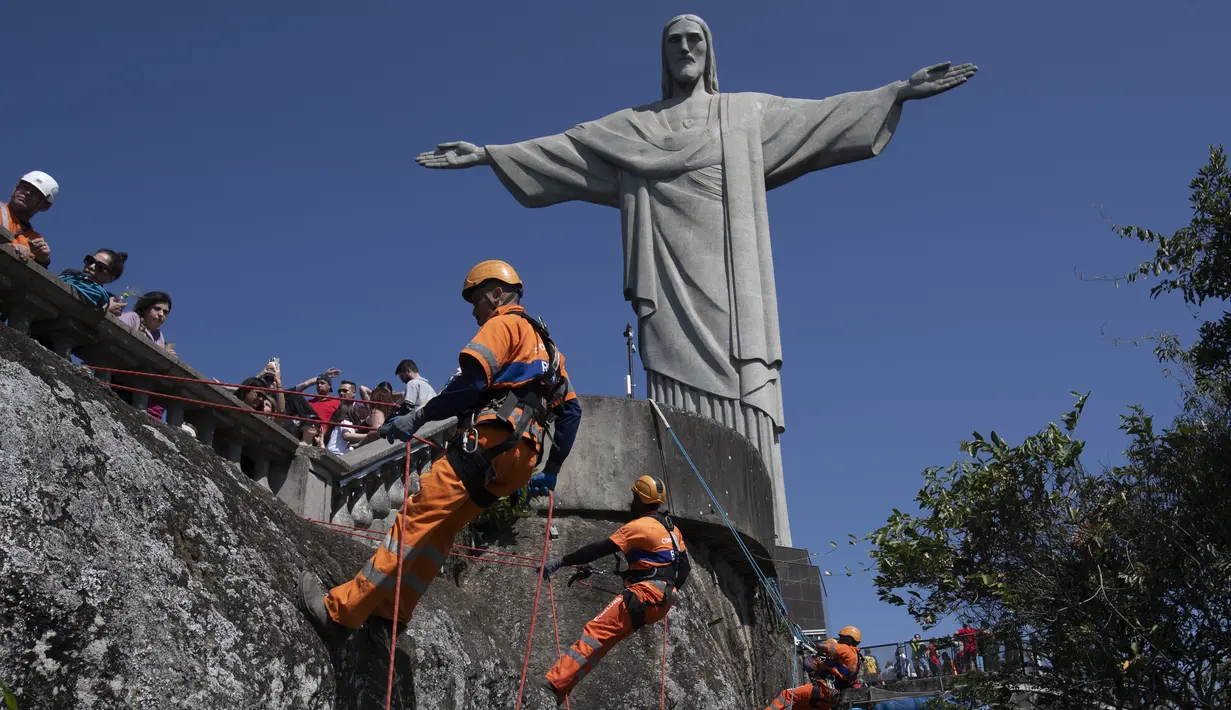 Para pembersih sampah menuruni Gunung Corcovado untuk membuang sampah yang dibuang di lereng Patung Kristus Penebus di Rio de Janeiro, Brasil pada Kamis, 22 Agustus 2024. (AP Photo/Bruna Prado)