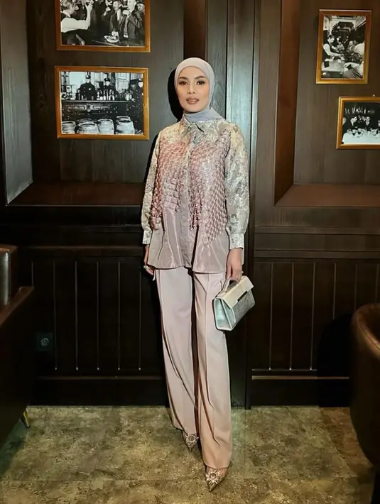 Nindy juga tampil mengenakan atasan lengan panjang yang dipadukan celana panjang yang memiliki kantung di kedua sisi. Ia pun mengenakan kerudung silver. [@nindyayunda]
