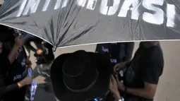 Massa dari Komite Warga Sentul City mengenakan payung hitam dalam aksi di depan Istana Negara, Senin (30/4). Mereka meminta proses hukum terhadap pengembang perumahan Sentul City karena diduga terjadi penguasaan pengelolaan air (Merdeka.com/Iqbal Nugroho)