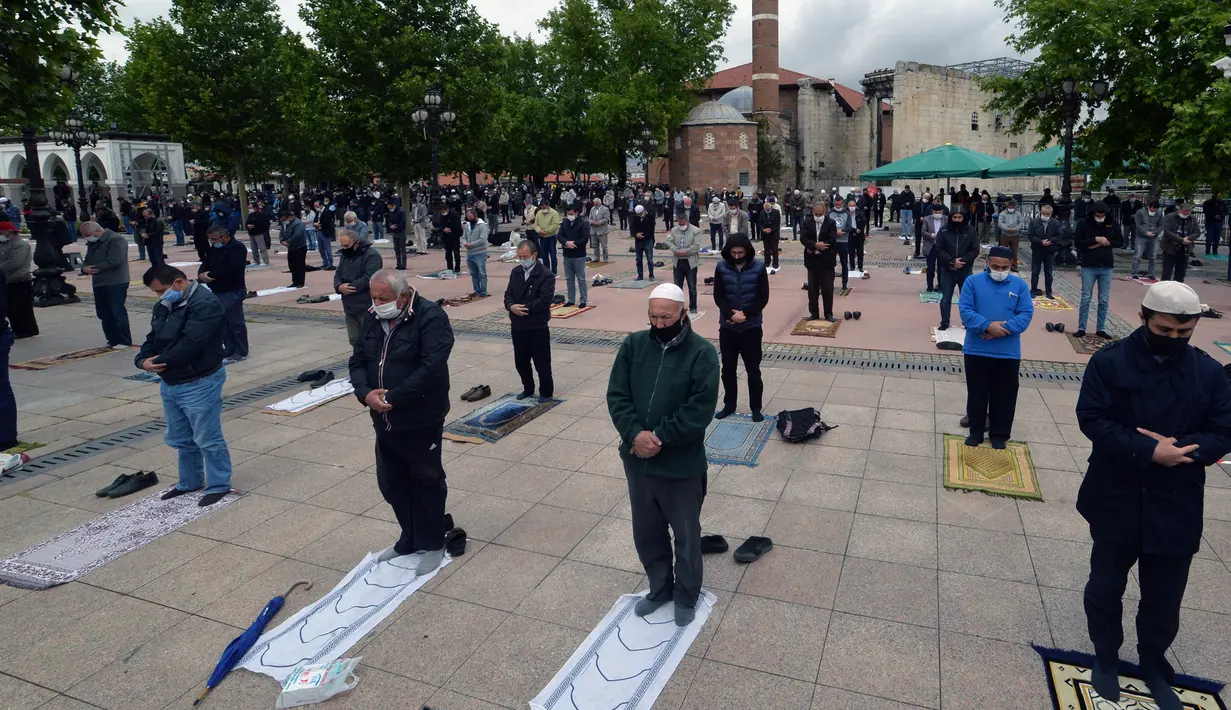 Warga yang mengenakan masker mengikuti salat Jumat dengan menjaga jarak di depan sebuah masjid di Ankara, 29 Mei 2020. Masjid-masjid di seluruh Turki pada Jumat (29/5) kembali dibuka, sebagai bagian proses normalisasi di tengah melambatnya penyebaran COVID-19 di negara itu. (Xinhua/Mustafa Kaya)