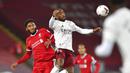 Pemain Liverpool, Joe Gomez, duel udara dengan striker Arsenal, Alexandre Lacazette, pada laga Liga Inggris di Stadion Anfield, Senin (28/9/2020). Liverpool menang dengan skor 3-1. (Paul Ellis/Pool via AP)