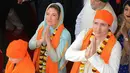 Perdana Menteri Kanada Justin Trudeau (kanan) bersama istrinya Sophie Gregoire (kiri) memberi penghormatan di Kuil Emas Sikh di Amritsar, India (21/2). Trudeau dan istri memakai busana khas India saat mengunjungi kuil tersebut. (AFP Photo/Narinder Nanu)