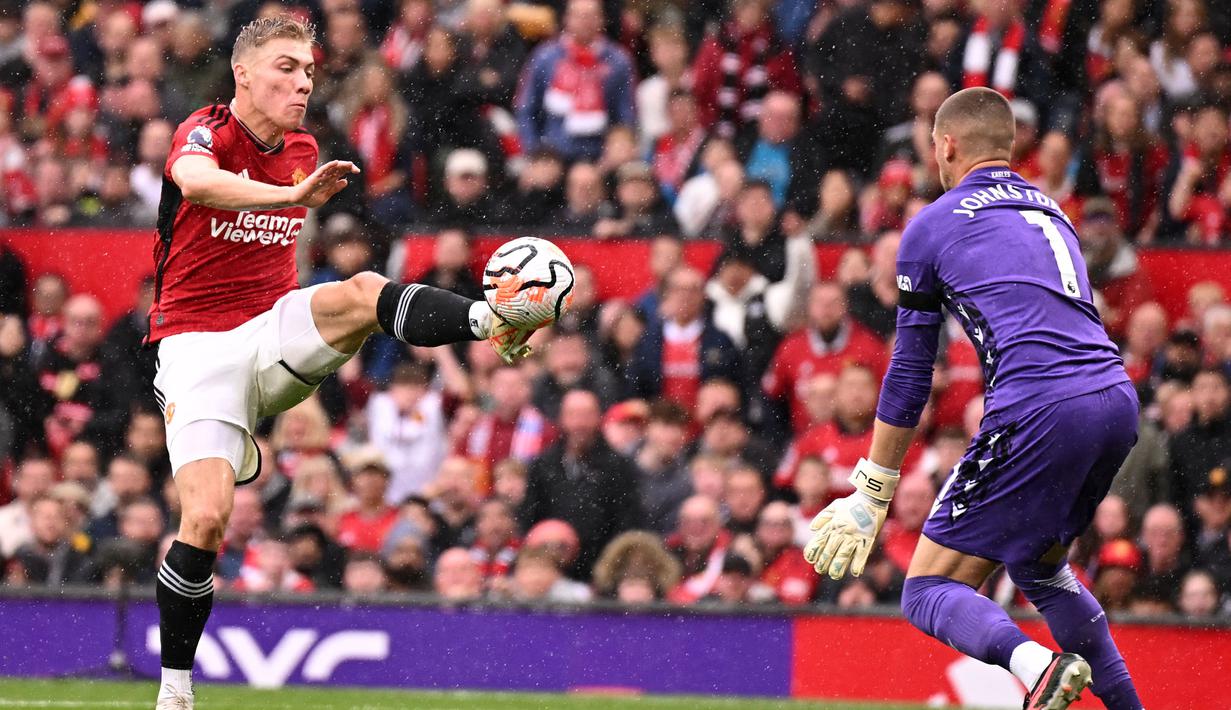 Pemain Manchester United, Rasmus Hojlund (kiri) berusaha mencetak gol ke gawang Crystal Palace yang dijaga oleh Sam Johnstone pada laga lanjutan Liga Inggris 2023/2024 di Old Trafford, Manchester, Inggris, 30 September 2023. (AFP/Oli Scarff)
