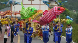 Warga desa mengenakan kostum tradisional ambil bagian dalam sebuah pawai di Distrik Tongliang di Chongqing, China (19/9/2020). Pertunjukan tari naga dan kegiatan rakyat lainnya digelar untuk merayakan festival panen petani China yang jatuh pada Equinox Musim Gugur setiap tahunnya. (Xinhua/Liu Chan)
