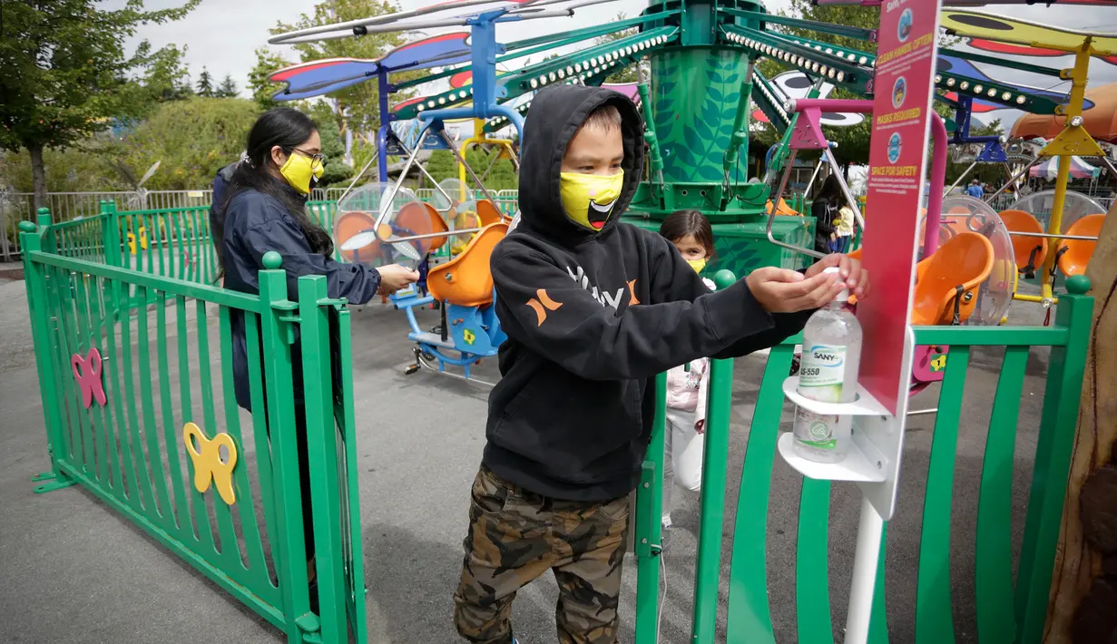Seorang pengunjung membersihkan tangannya usai menaiki wahana di Playland Amusement Park, di Vancouver, British Columbia, Kanada, pada 10 Juli 2020. Playland Amusement Park dibuka kembali untuk umum pada Jumat (10/7), dengan langkah-langkah protokol kesehatan. (Xihua/Liang Sen)