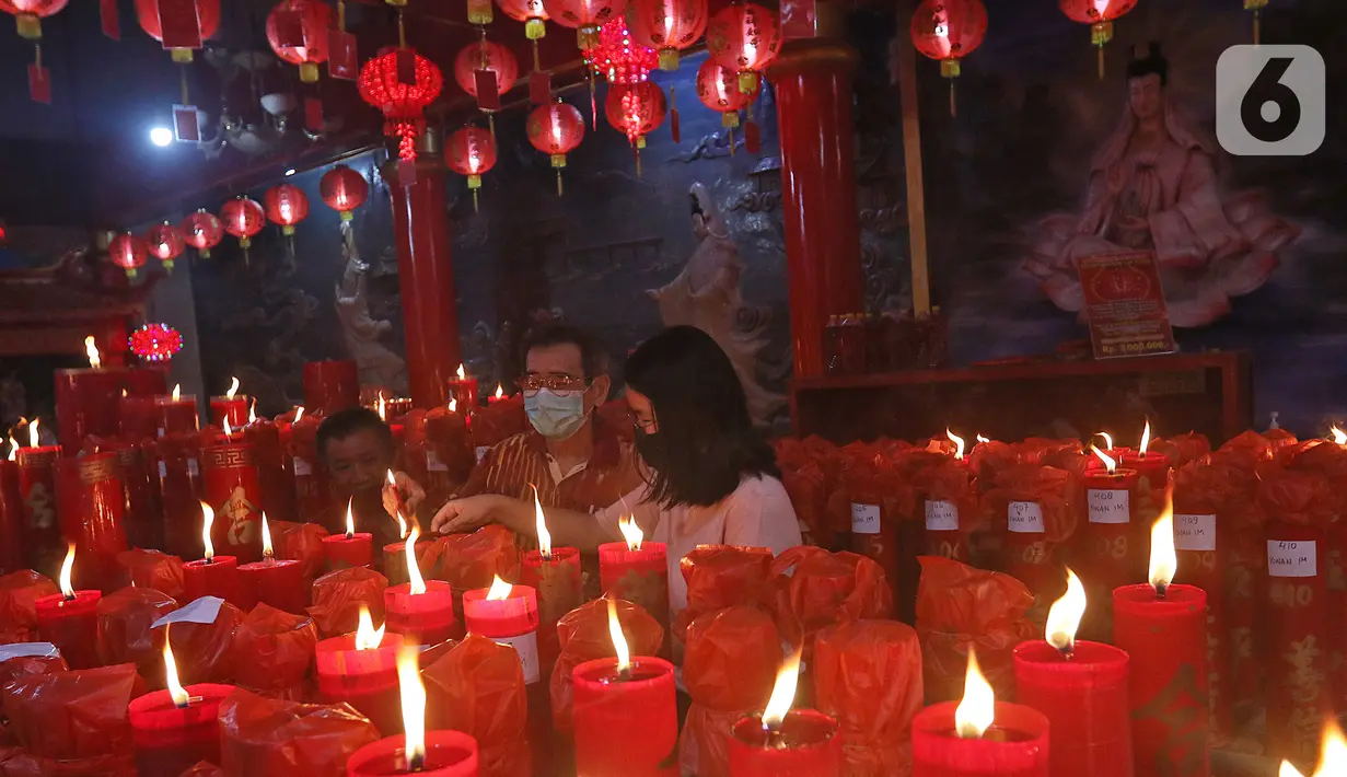 Warga keturunan Tionghoa menyalakan lilin di Klenteng Hok Lay Kiong, Bekasi, Kamis (11/2/2021). Sembahyang di malam Imlek ini sebagai ungkapan syukur atas rezeki dan keselamatan dari Tuhan serta untuk pengharapan kehidupan lebih baik di tahun Kerbau. (Liputan6.com/Herman Zakharia)