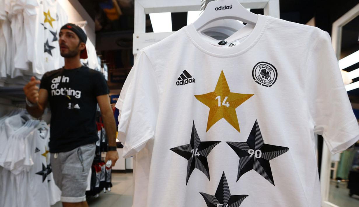 Salah satu petugas toko di Frankfurt, (14/7/2014), melintas diantara kaos-kaos berlogo federasi sepak bola Jerman dengan empat bintang. (REUTERS/Ralph Orlowski)