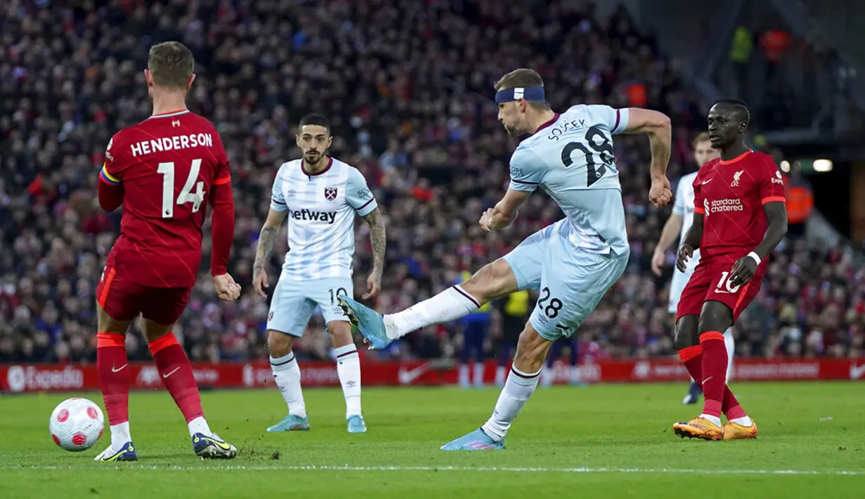 Pemain West Ham United Tomas Soucek menendang bola melewati pemain Liverpool Jordan Henderson (kiri) pada pertandingan sepak bola Liga Inggris di Stadion Anfield, Liverpool, Inggris, 5 Maret 2022. Liverpool menang 1-0. (AP Photo/Jon Super)