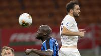 Penyerang Inter Milan, Romelu Lukaku berebut bola dengan gelandang Fiorentina, Milan Badelj pada pertandingan lanjutan Liga Serie A Italia di di stadion San Siro di Milan, Italia, Rabu, (22/7/2020). Inter Milan bermain imbang 0-0 atas Fiorentina. (AP Photo/Luca Bruno)