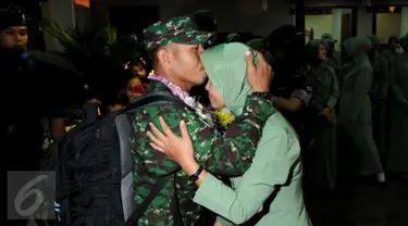 Personel TNI AD yang tergabung dalam kontingen AASAM mencium kening pasangannya saat penyambutan kedatangan di Bandara Soetta, Banten, Senin (23/5/2016). TNI AD menjadi juara umum AASAM 2016 yang digelar di Australia. (Liputan6.com/Helmi Fithriansyah)