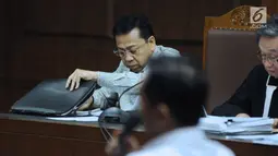Terdakwa dugaan korupsi proyek e-KTP, Setya Novanto melihat berkas saat menyimak keterangan saksi pada sidang lanjutan di Pengadilan Tipikor, Jakarta, Senin (12/3). Sidang mendengar keterangan saksi dan saksi ahli. (Liputan6.com/Helmi Fithriansyah)