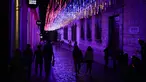 Orang-orang berjalan di jalan yang dihiasi lampu warna-warni bendera Venezuela di pusat Kota Caracas, Venezuela, 5 Februari 2022. (AP Photo/Ariana Cubillos)