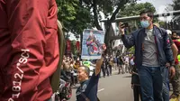 Antusias warga menyaksikan parade pembalap MotoGP di kawasan Jakarta, Rabu (16/3/2022).  Sebanyak 20 pembalap MotoGP menjajal ruas Jalan Sudirman-Thamrin, Jakarta Pusat hari ini. (Liputan6.com/Faizal Fanani)