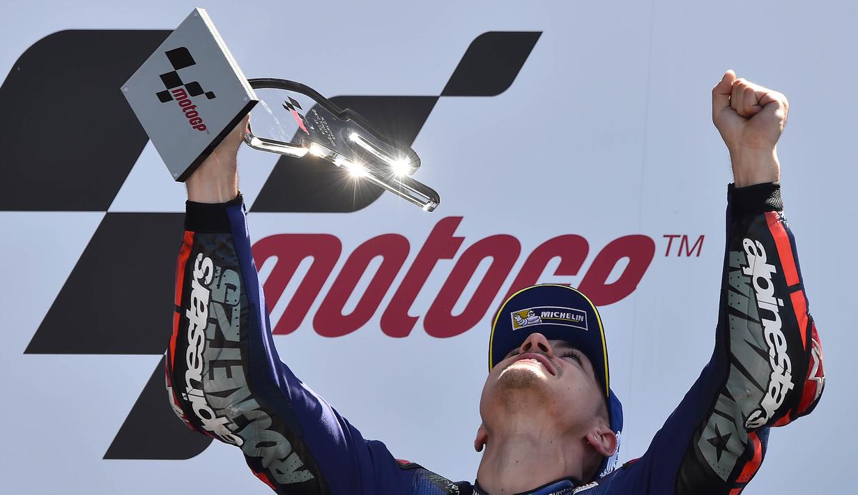 Pebalap Movistar Yamaha, Maverick Vinales, tampak gembira mengangkat piala merayakan gelar juara MotoGP Prancis. (AFP/Jean-Francois Monier) 