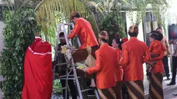 Presiden Joko Widodo (Jokowi) menaiki tangga untuk memasang bleketepe di kediamannya Jalan Kutai Utara, Solo, Selasa (7/11). Pemasangan bleketepe itu merupakan bagian dari prosesi adat pernikahan Kahiyang Ayu dan Bobby Nasution (Liputan6.com/Angga Yuniar)