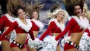 Sejumlah pemandu sorak (cheerleader) Cowboys Dallas berkostum santa claus menghibur penonton saat tim Cowboys Dallas istirahat pada pertandingan Seattle Seahawks di AT & T Stadium, Texas (24/12). (AFP / Getty Images / Tom Pennington)